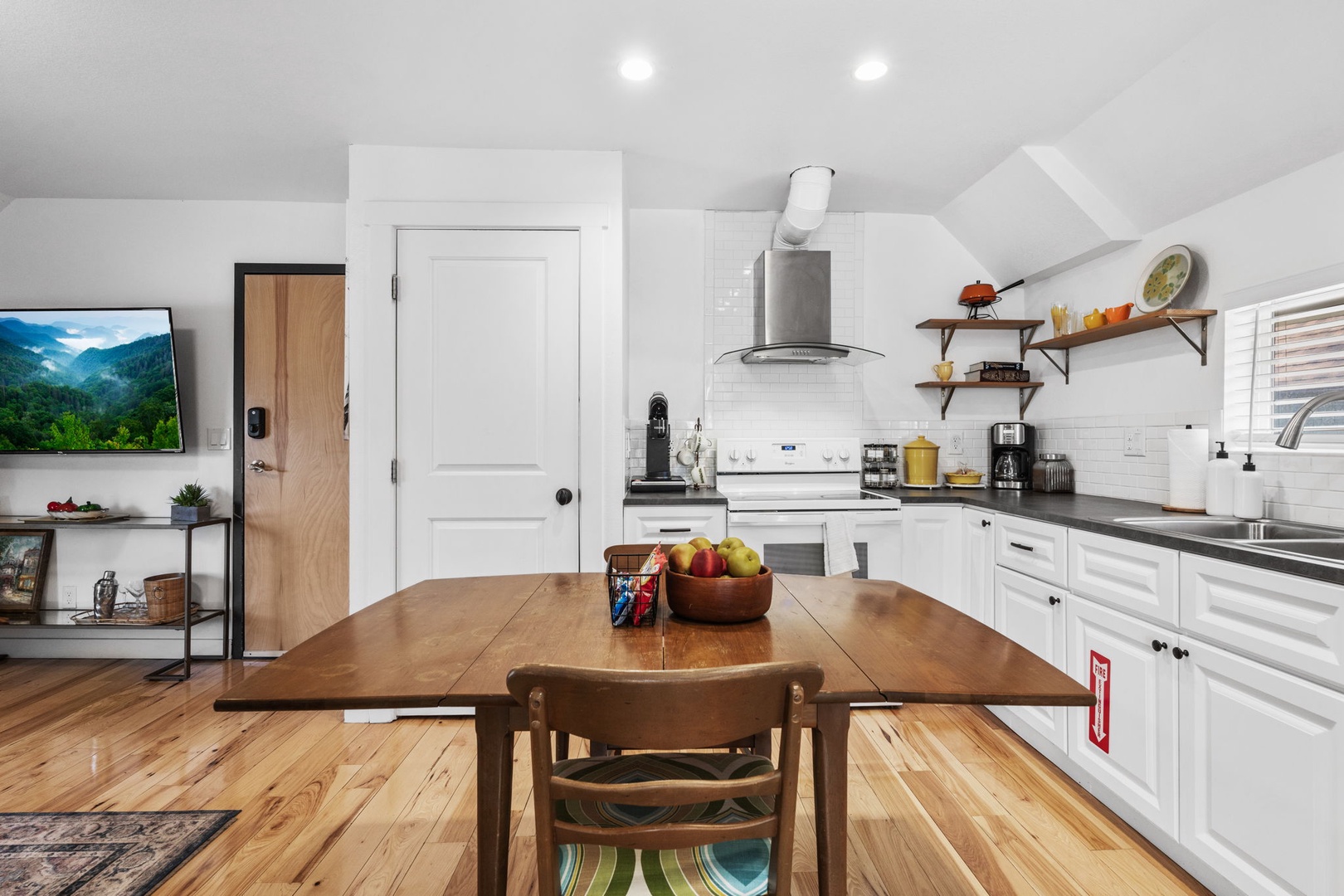 Your bright, fully-equipped kitchen invites home-cooked meals with modern appliances, warm wood accents, and a cozy dining table perfect for morning coffee.