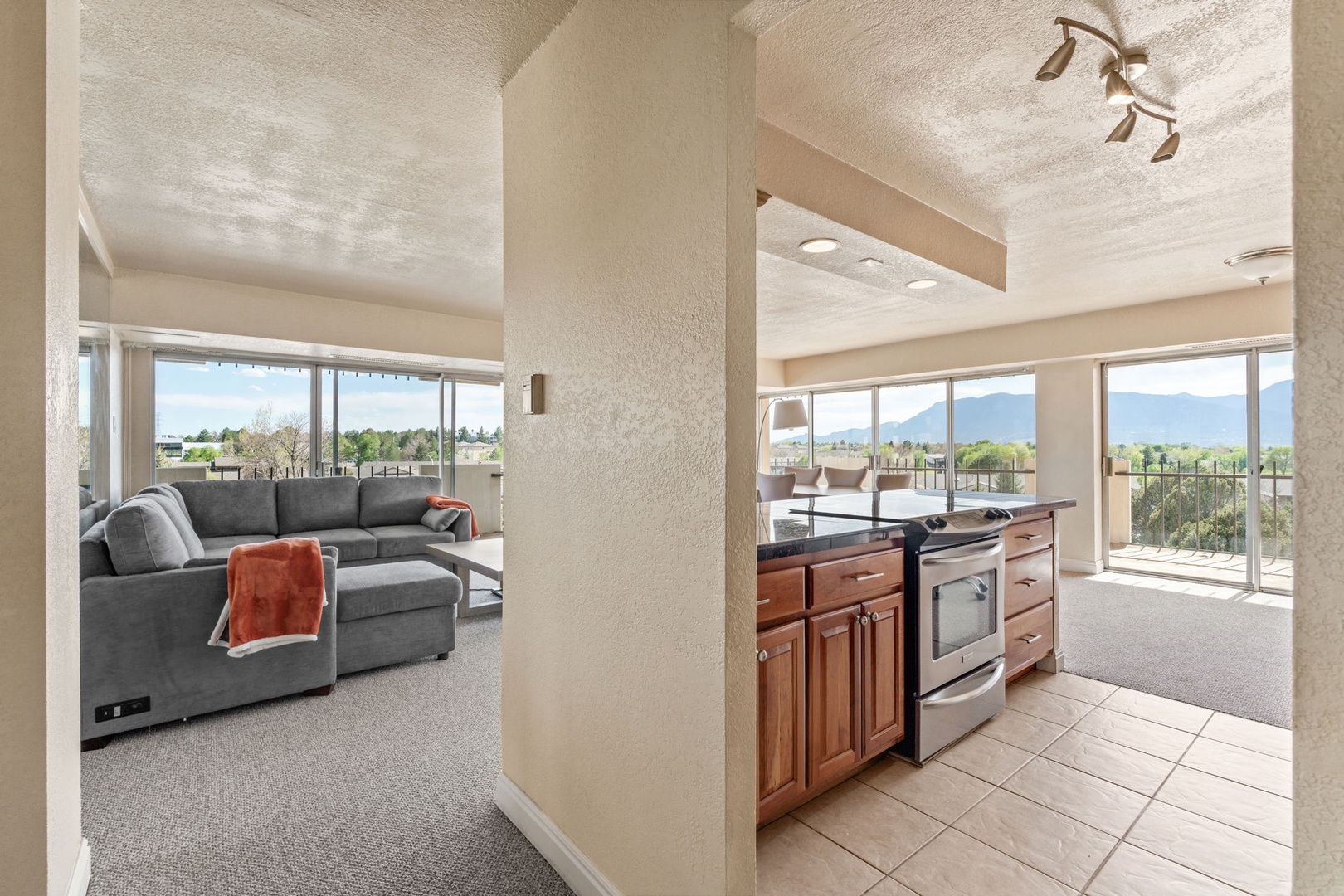 Relax in this open, sunlit space where mountain views frame every moment. The kitchen flows seamlessly into a cozy living area, inviting you to cook, unwind, and soak in the natural beauty just beyond the glass.