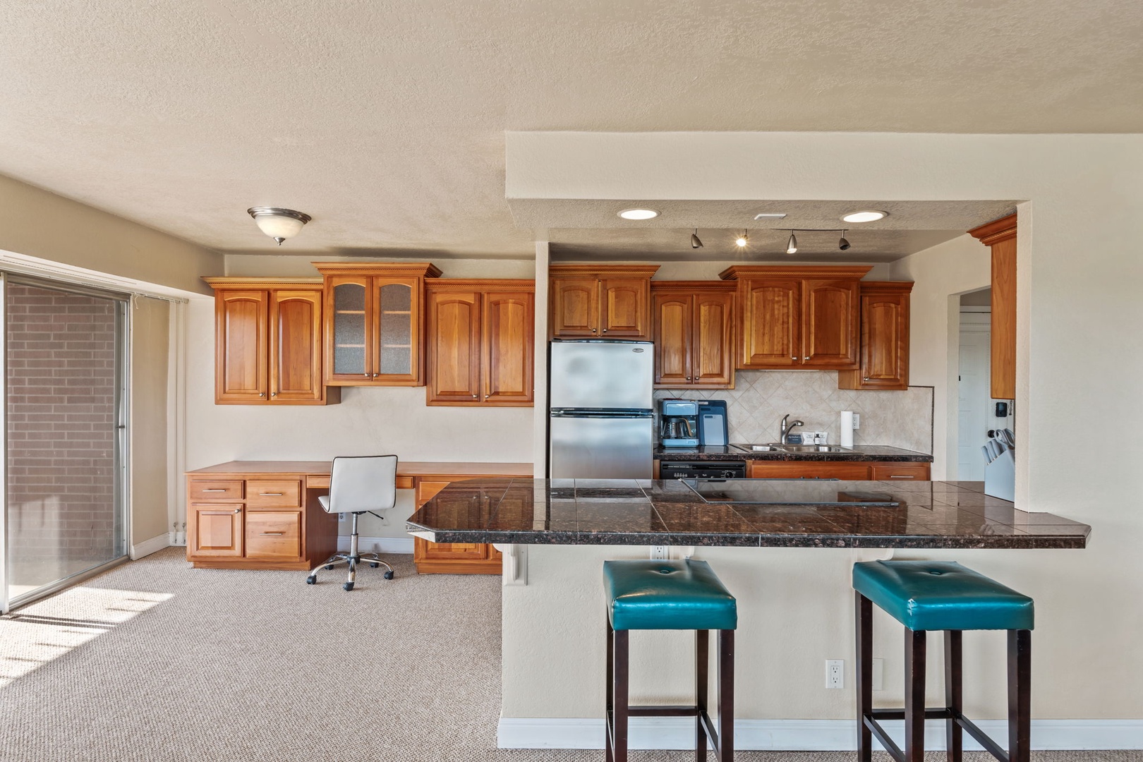 Gather around the breakfast bar in your well-equipped kitchen, complete with granite counters, warm wood cabinetry, and stainless steel appliances for easy meal prep during your stay.