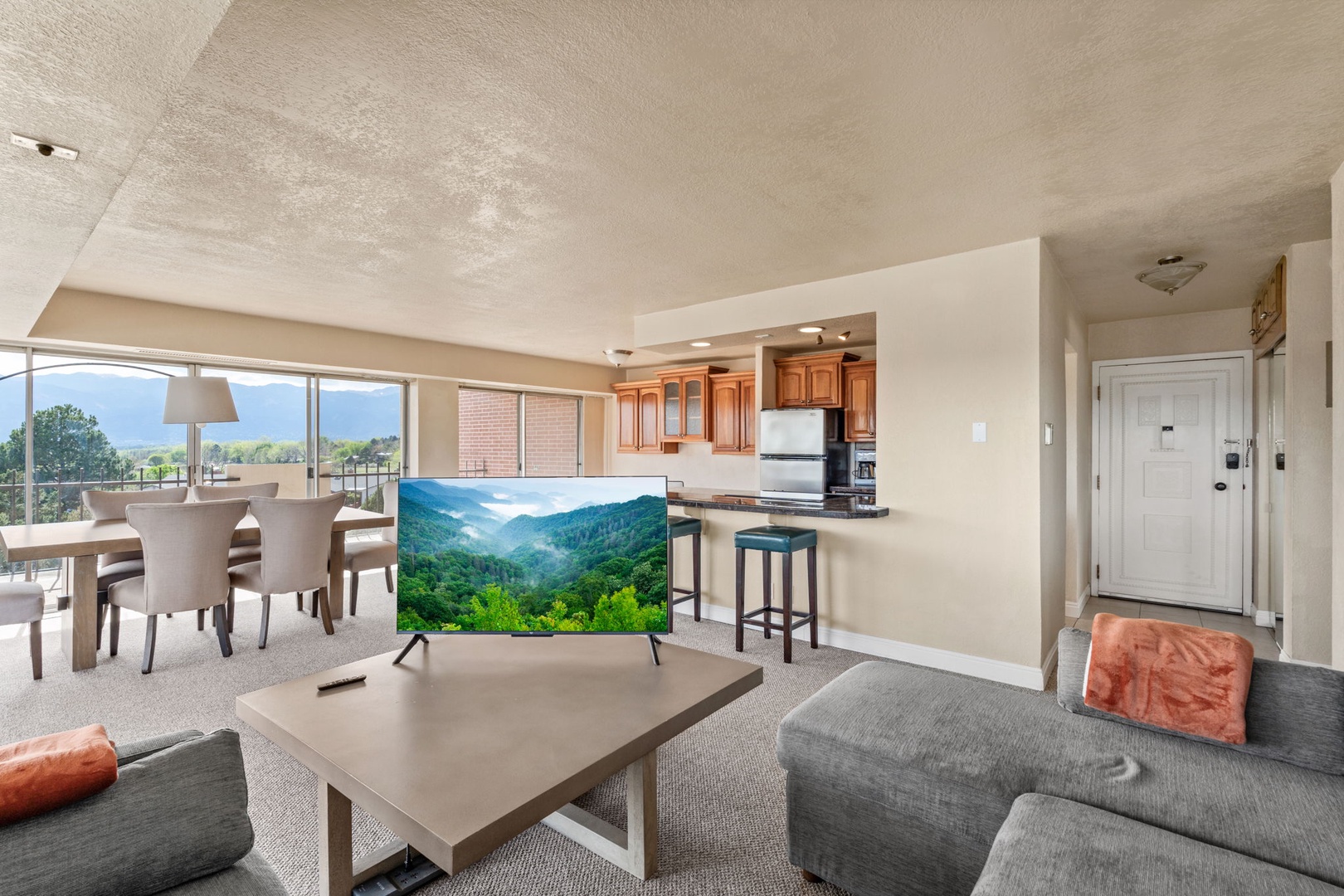 Settle into your spacious living area and enjoy stunning mountain views through expansive windows. The open-concept design flows seamlessly into the fully equipped kitchen and dining space, perfect for gathering with loved ones.