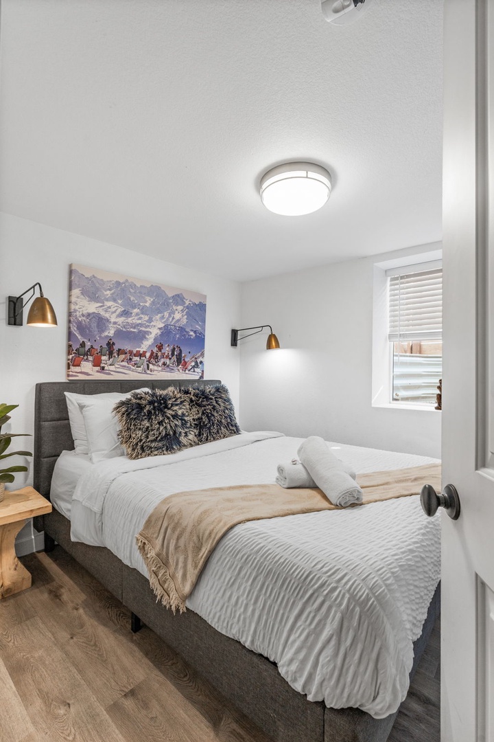 Sink into crisp white linens and cozy textures in your mountain-inspired bedroom, where warm brass sconces create perfect reading light.