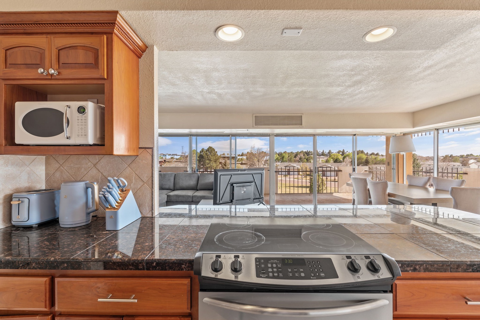 Your fully equipped kitchen features modern appliances and a sunny view, making meal prep a breeze. With a sleek stove, microwave, and plenty of counter space, you'll feel right at home.