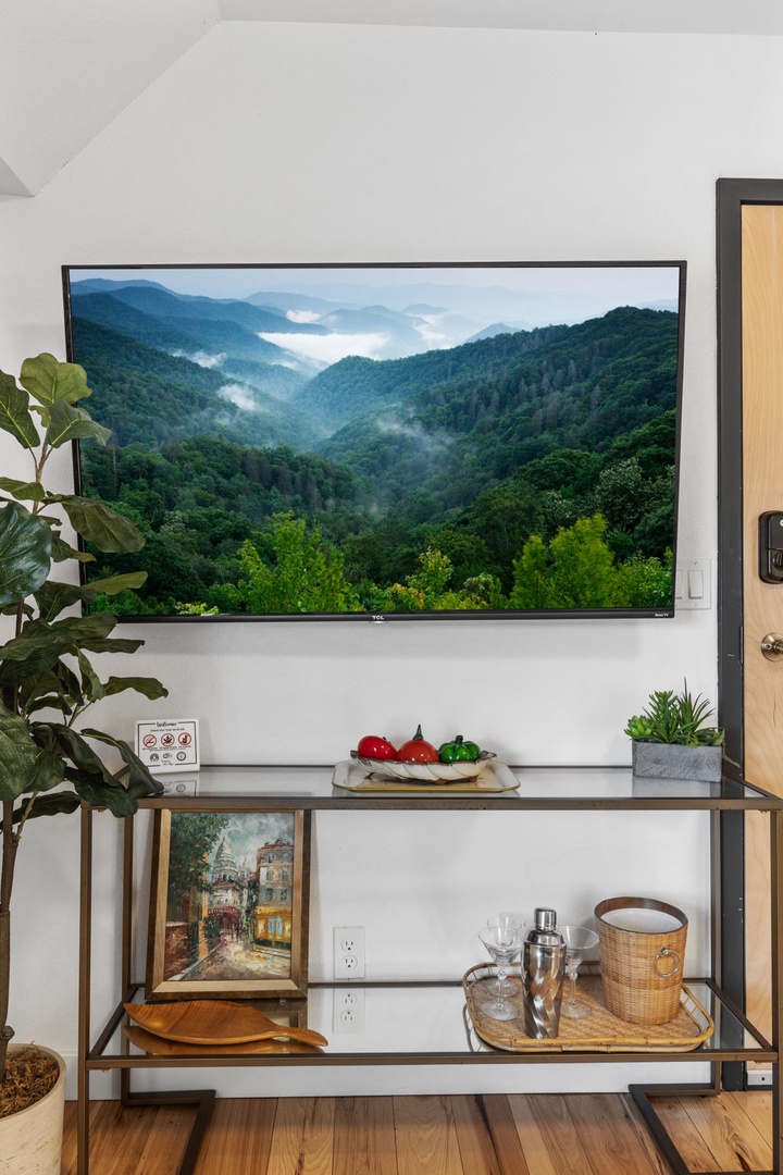 Unwind in your cozy entertainment area where misty mountain views grace the wall-mounted TV, creating a serene backdrop for relaxation.