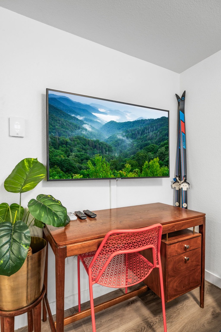 Your personal workspace features a sleek TV and warm wooden desk, creating the perfect blend of productivity and relaxation.