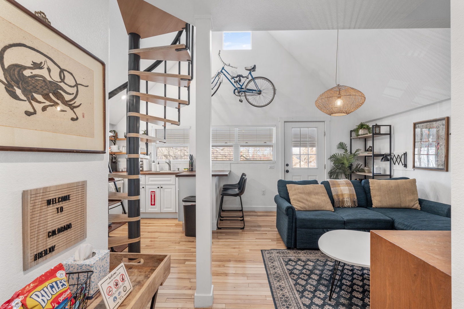 Unwind in your stylish loft with warm wood floors, cozy blue sofa, and charming details throughout.