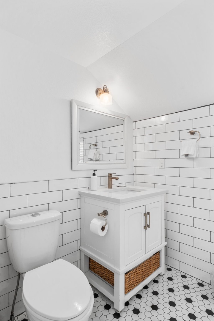 Step into your charming bathroom featuring classic subway tiles, vintage-inspired fixtures, and a stylish vanity with wicker basket storage.