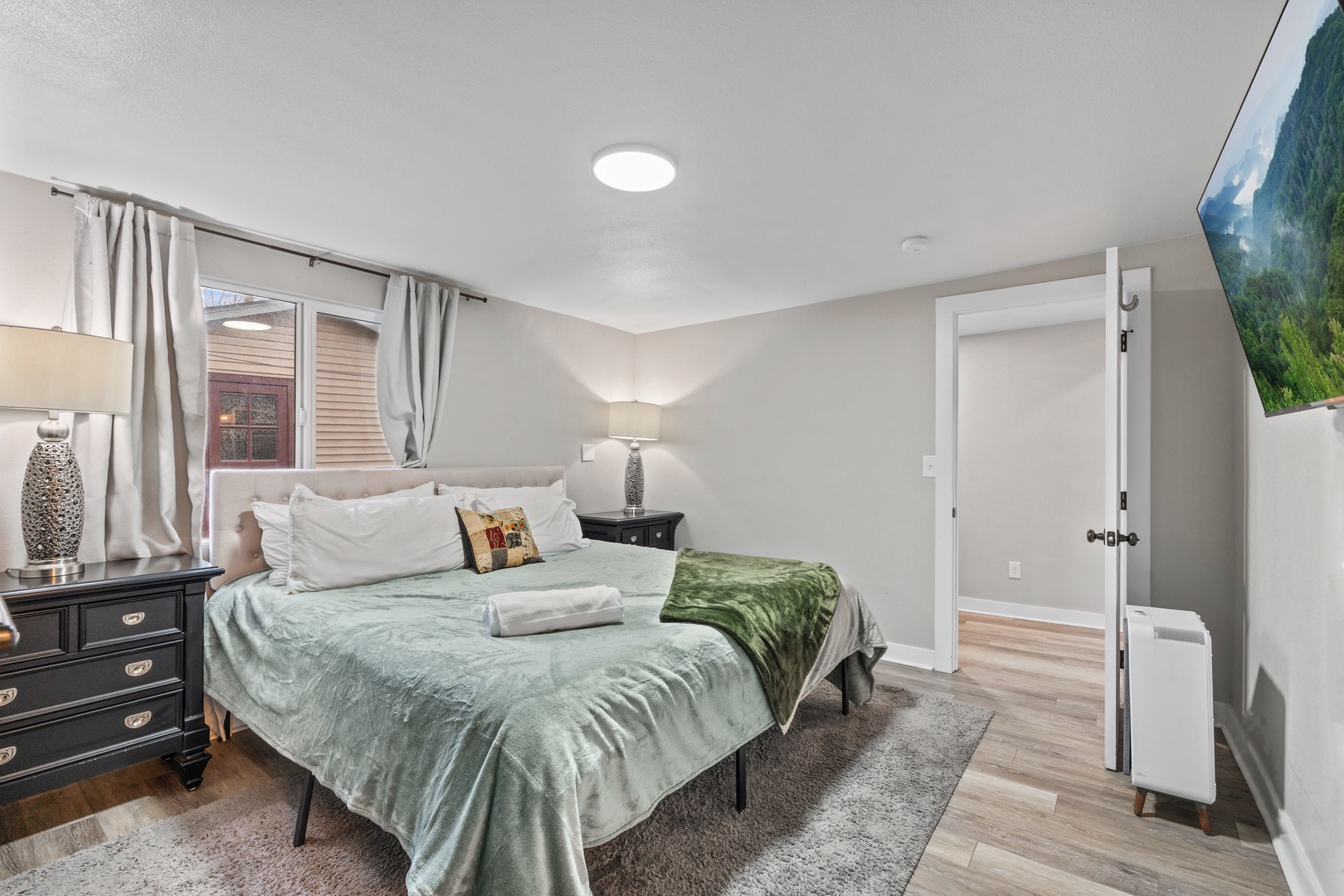 Unwind in your peaceful bedroom featuring a comfortable queen bed with soft linens, elegant furnishings, and warm lighting for a restful night's sleep.