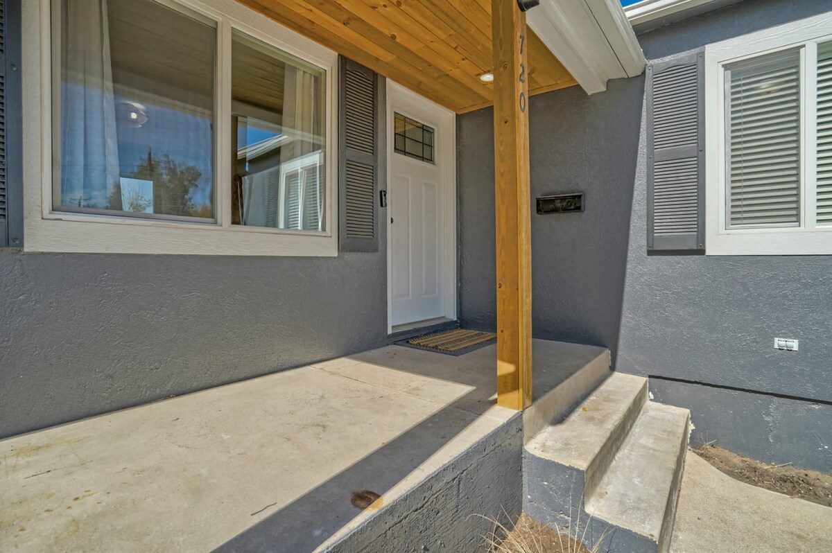 Modern property entrance featuring a welcoming covered porch with natural wood detailing and clean architectural lines.