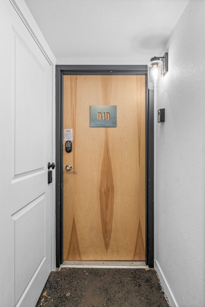 A welcoming entrance with modern wood-grain door and stylish lighting creates your perfect arrival experience.