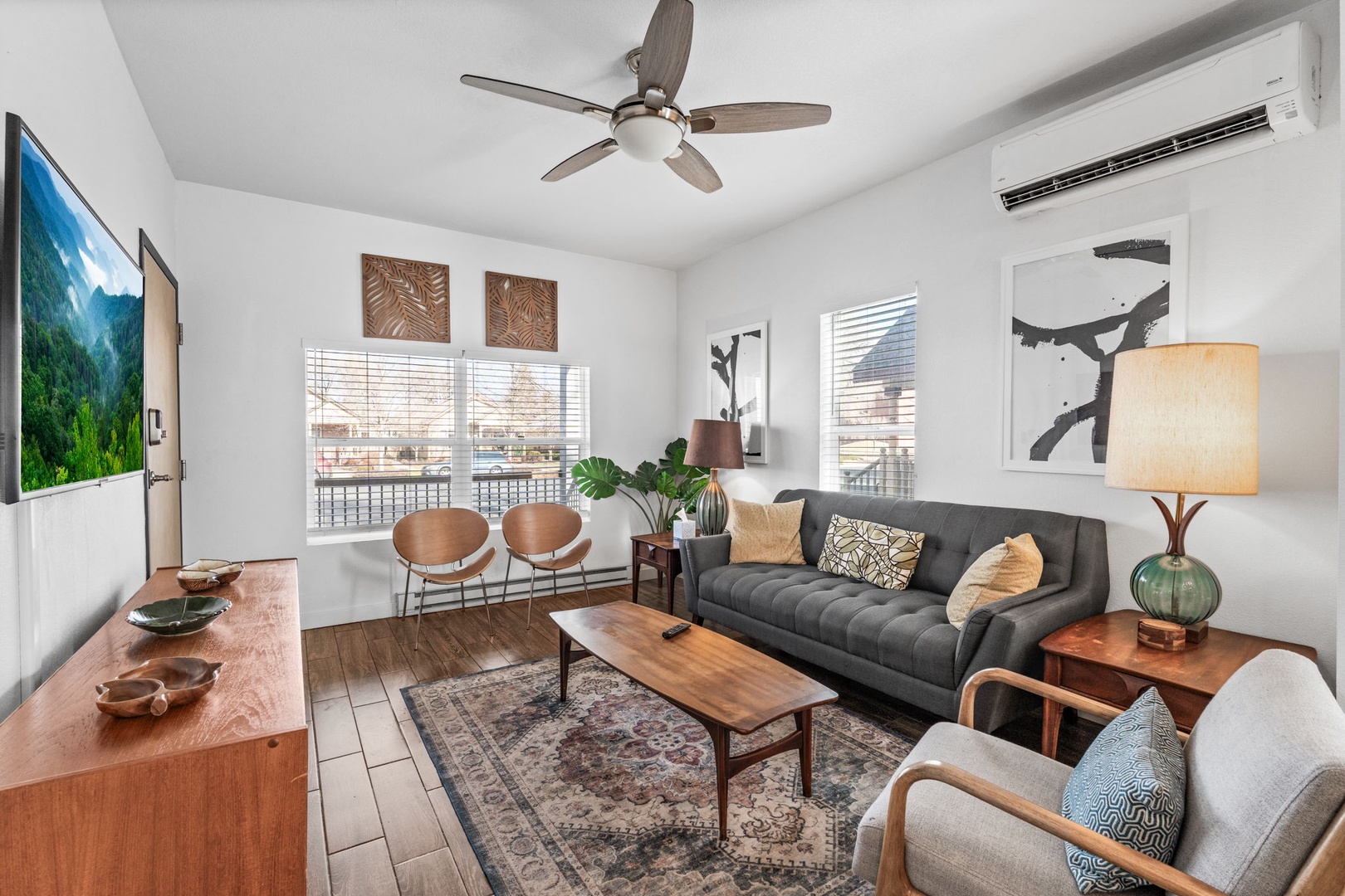 Sink into your stylish living room where modern comfort meets warm wood tones, complete with AC and TV for perfect relaxation.