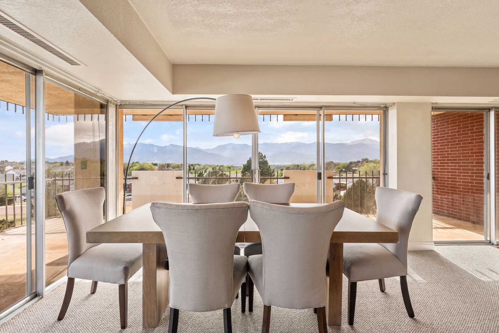 Gather around the elegant dining table and take in sweeping mountain views through floor-to-ceiling windows. Natural light fills the space, creating a warm ambiance for memorable meals.