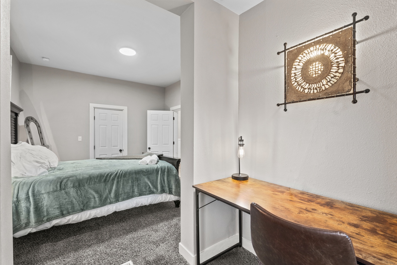 Your comfortable bedroom retreat features a cozy workspace where you can catch up on emails or plan your adventures, complete with thoughtful decor and warm lighting.