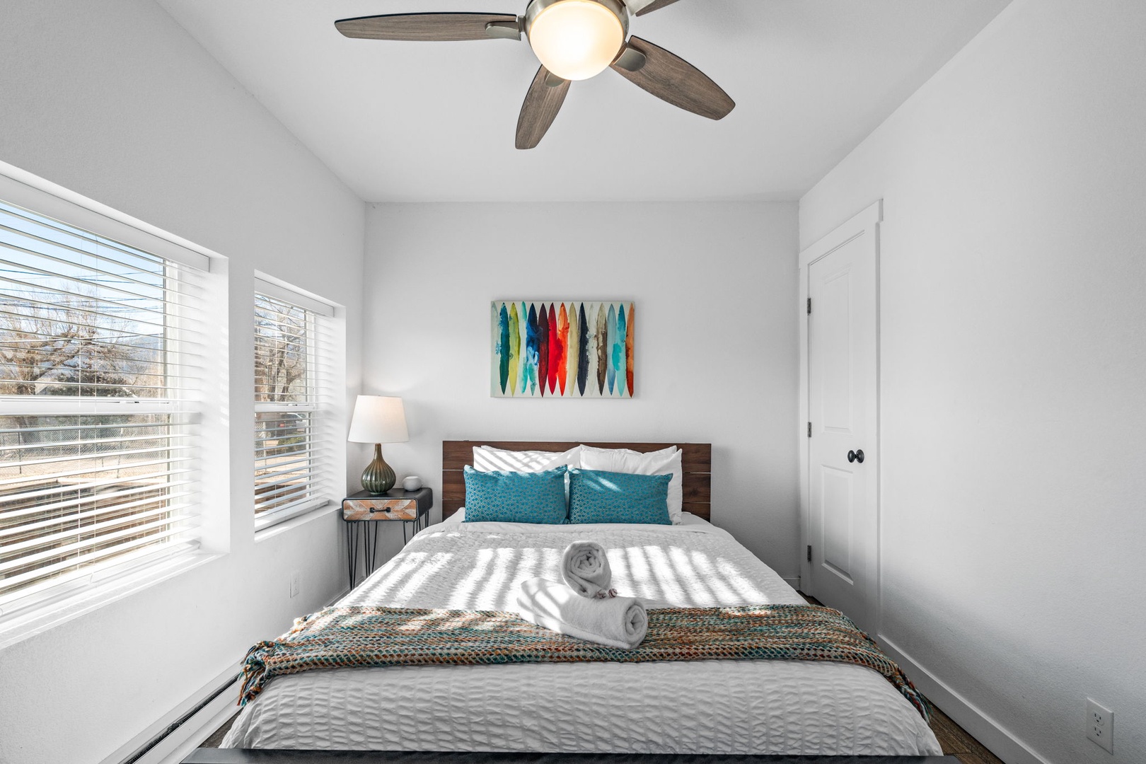 Rest peacefully in your bright bedroom featuring crisp linens, gentle ceiling fan breezes, and colorful artwork that adds personality to your stay.