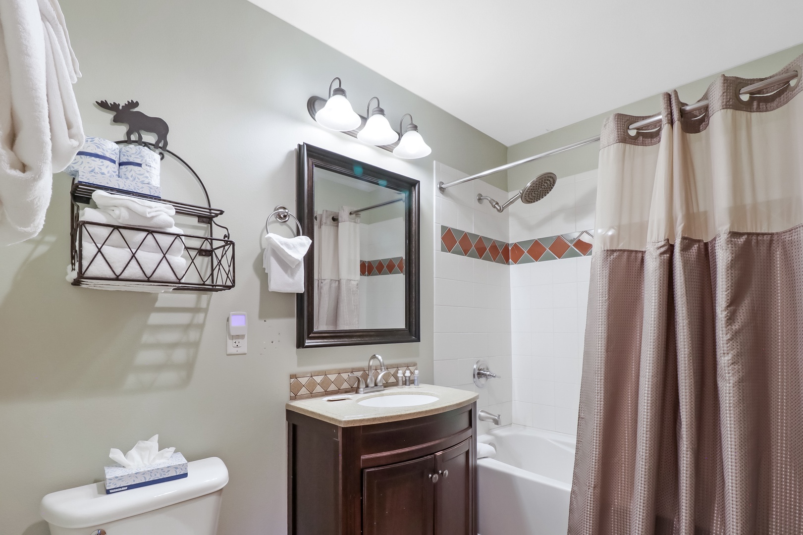 Step into your spotless bathroom with fresh towels, decorative touches, and a spacious tub-shower combo ready for your arrival.