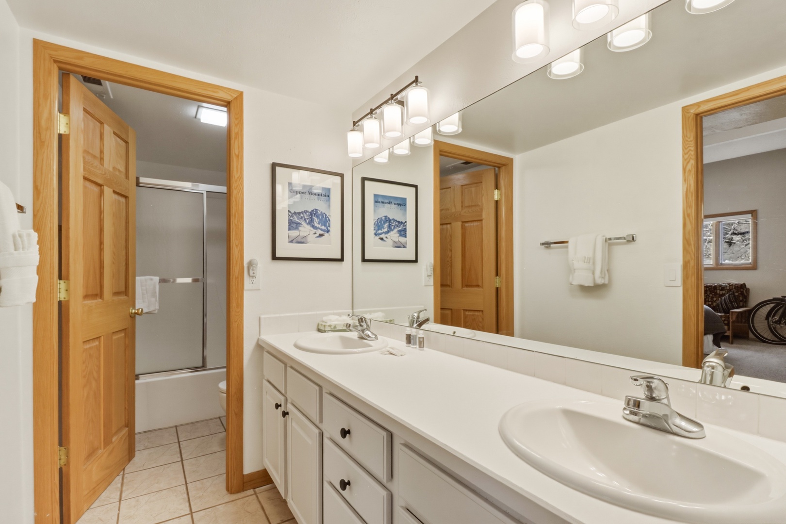 Step into your spacious bathroom featuring dual vanities, perfect for sharing morning routines with plenty of counter space and bright lighting.