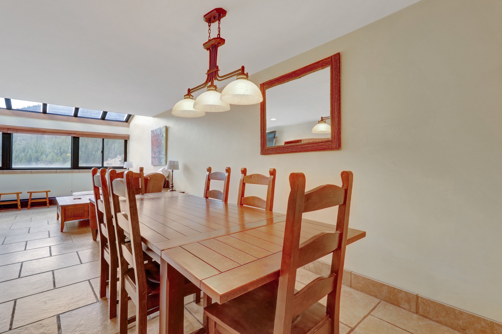 Warm and inviting dining space featuring a solid wood table with seating for six and a classic overhead light fixture. Perfect for family meals or après-ski gatherings.