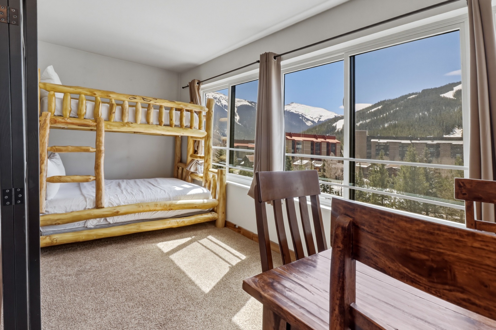 Wake up to breathtaking mountain views from your cozy bunk bed room, where adventure meets comfort in this ski-country retreat.