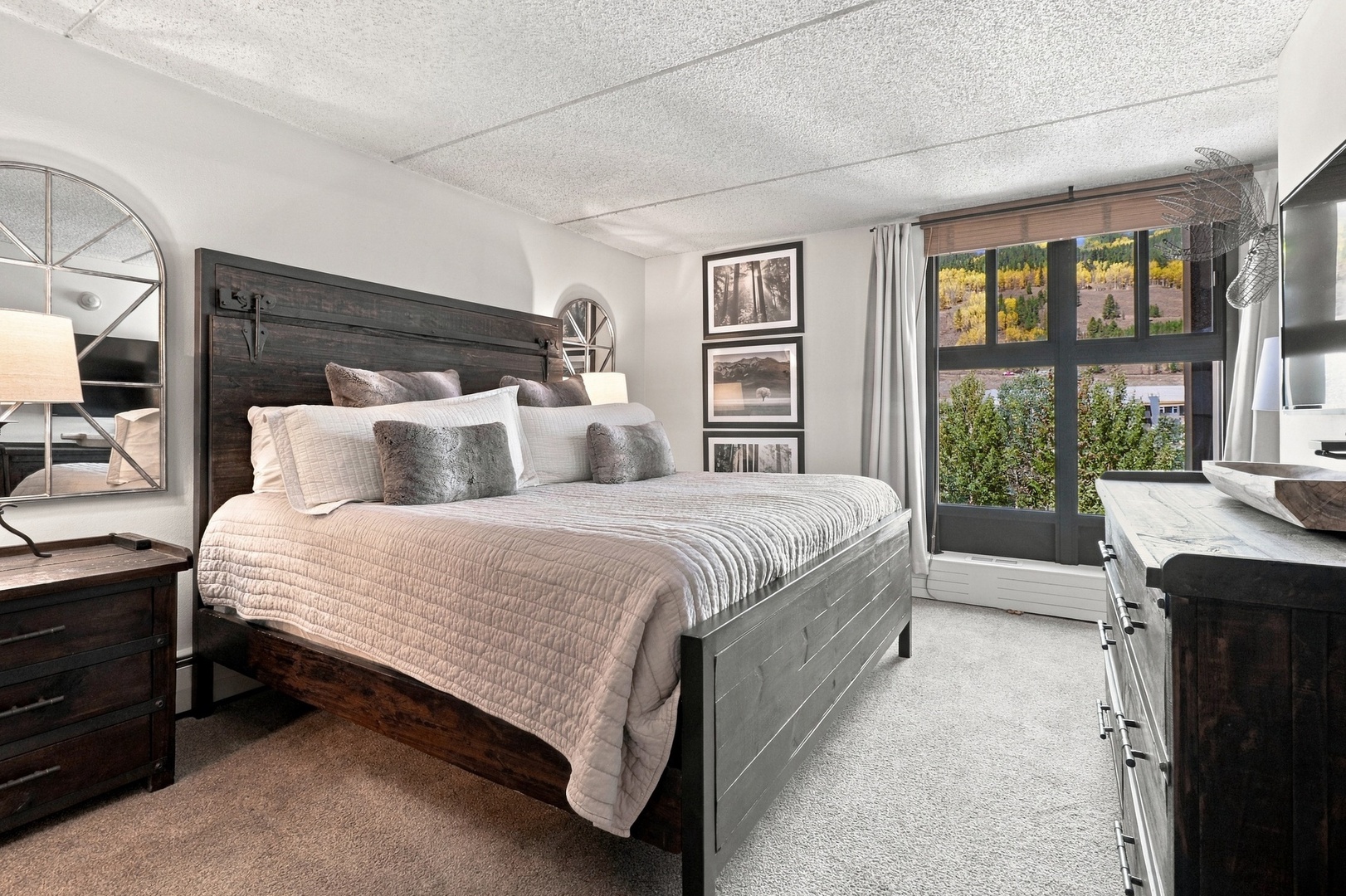 Sink into plush layers of comfort in your private bedroom retreat, where soft textures and a peaceful palette invite restful nights. Wake to vibrant mountain views through your own balcony door.