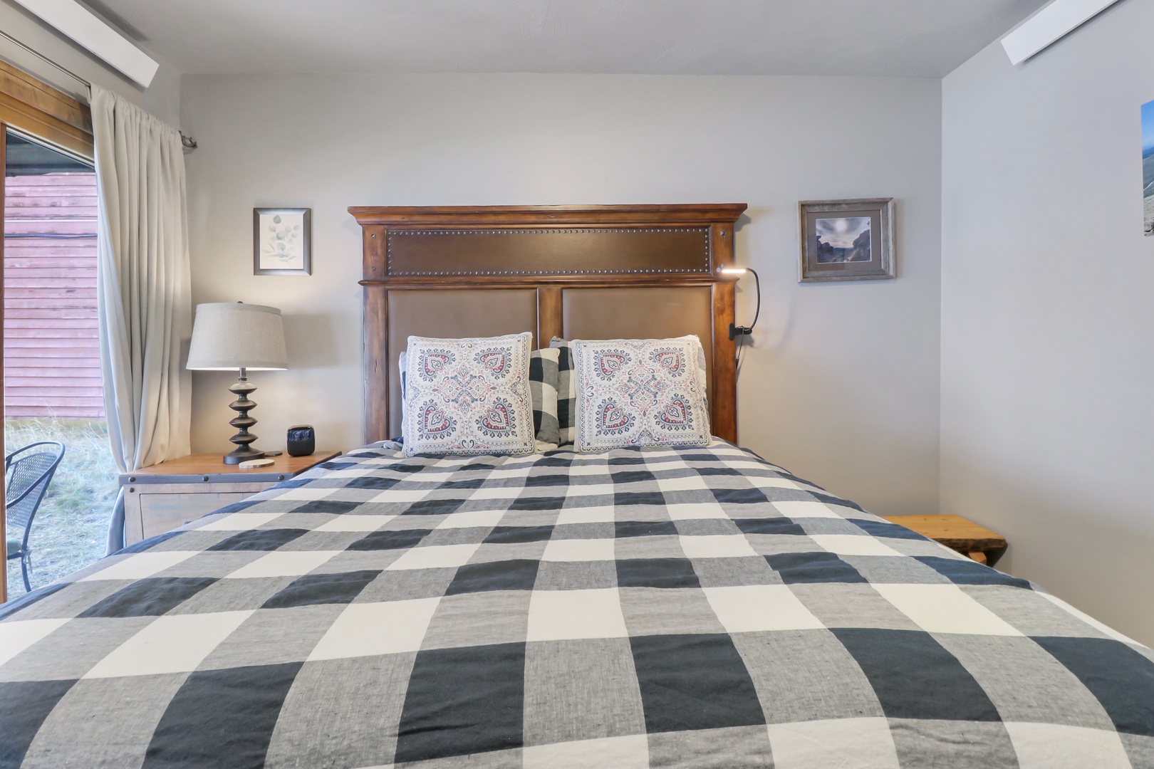 Drift off to sleep in this charming bedroom where rustic wood meets modern comfort. You'll love the cozy plaid bedding and thoughtful touches that make this space feel like home.
