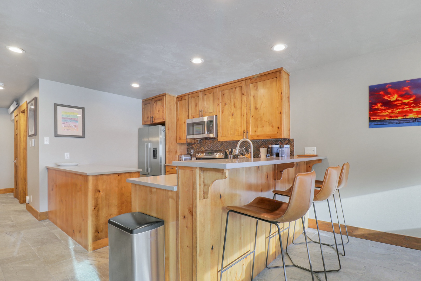 Your fully equipped kitchen awaits with warm wood cabinetry and modern appliances. Pull up a stool at the breakfast bar and plan your mountain adventures over morning coffee.