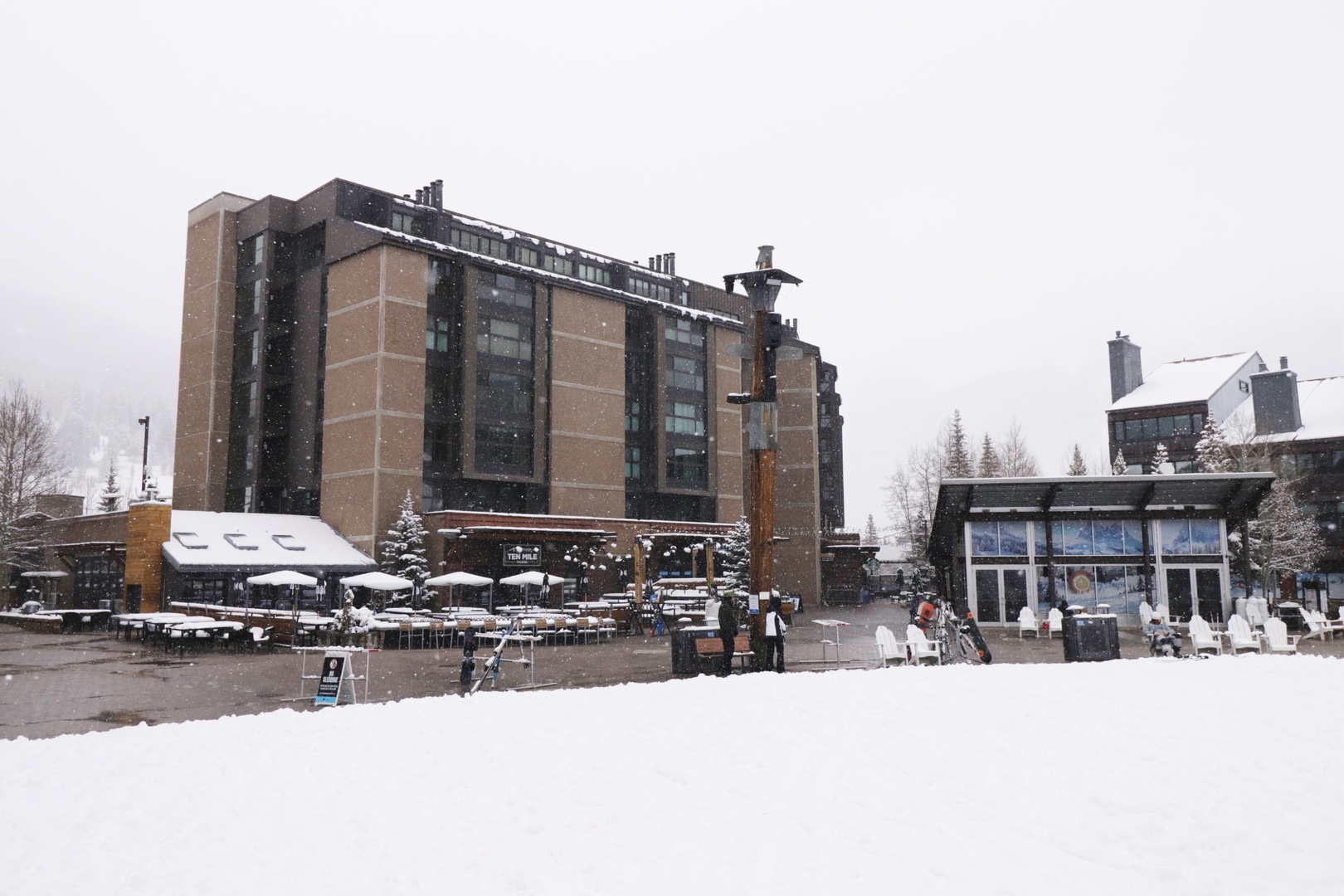 Multi-level property building nestled in a snowy mountain setting, with ski slopes nearby and winter activities at your doorstep.