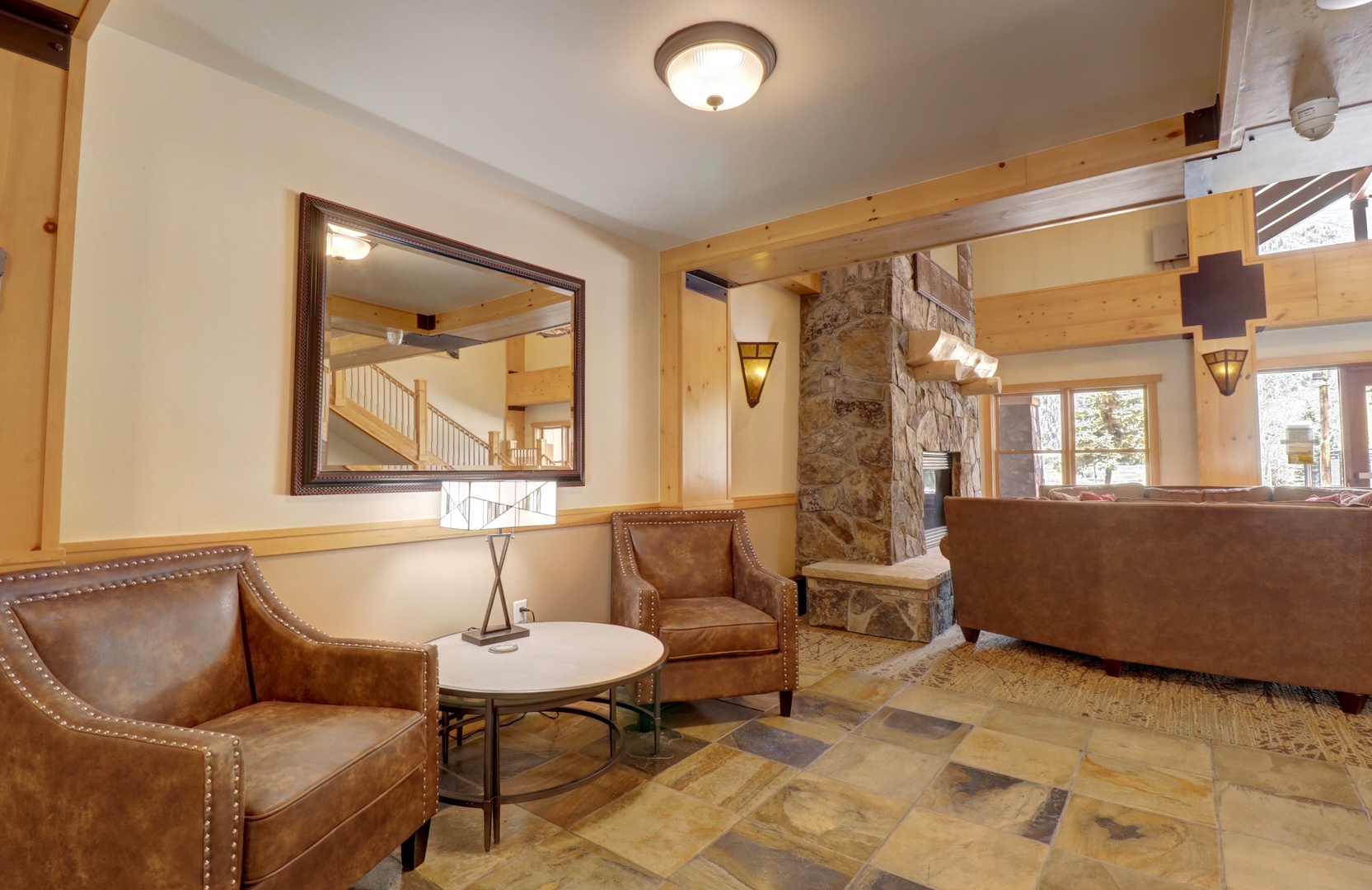 Step into your welcoming lobby where warm leather seating and rustic stone accents create an inviting mountain retreat atmosphere the moment you arrive.