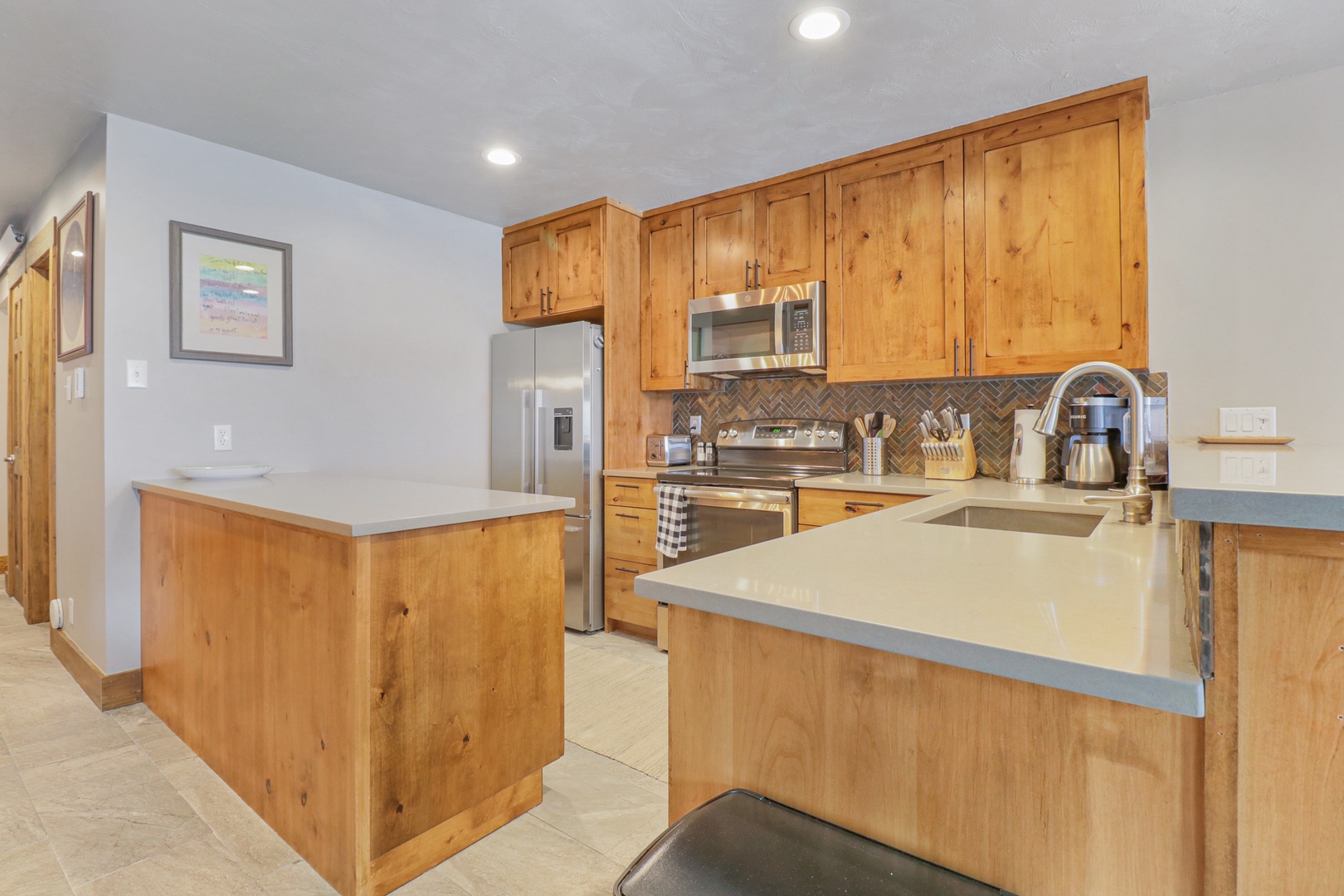Your fully equipped kitchen awaits with warm knotty pine cabinets and modern appliances, perfect for preparing meals while you enjoy mountain getaway moments together.