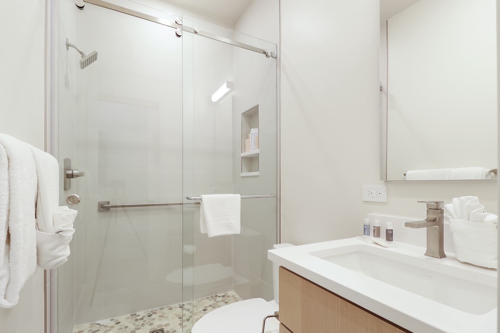 Freshen up in your sleek, modern bathroom with a spacious walk-in shower, crisp white towels, and spa-inspired amenities waiting for you.