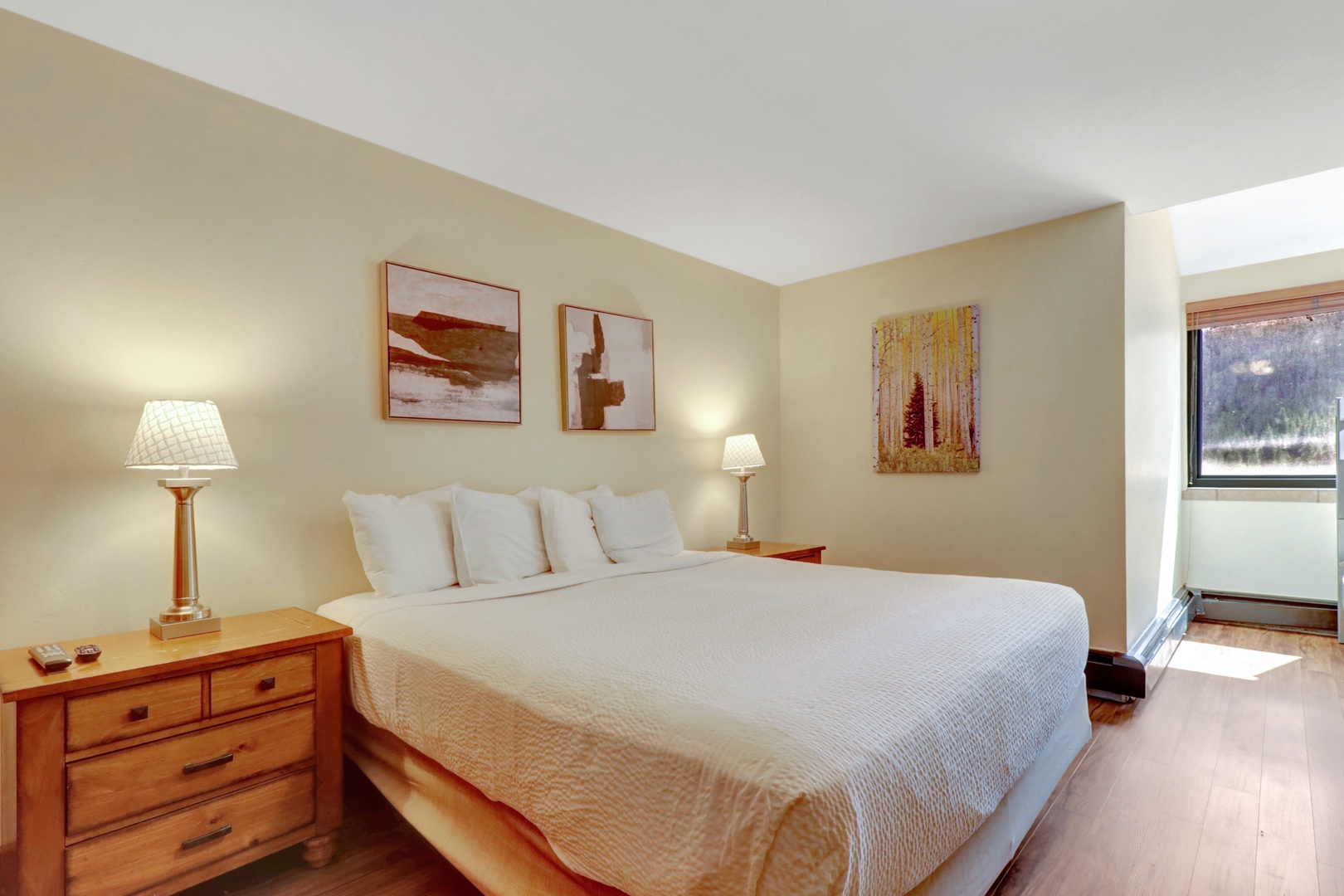 Inviting king bedroom featuring cozy bedding, warm wood furnishings, and tasteful artwork. Perfect for a restful night after exploring the mountain.