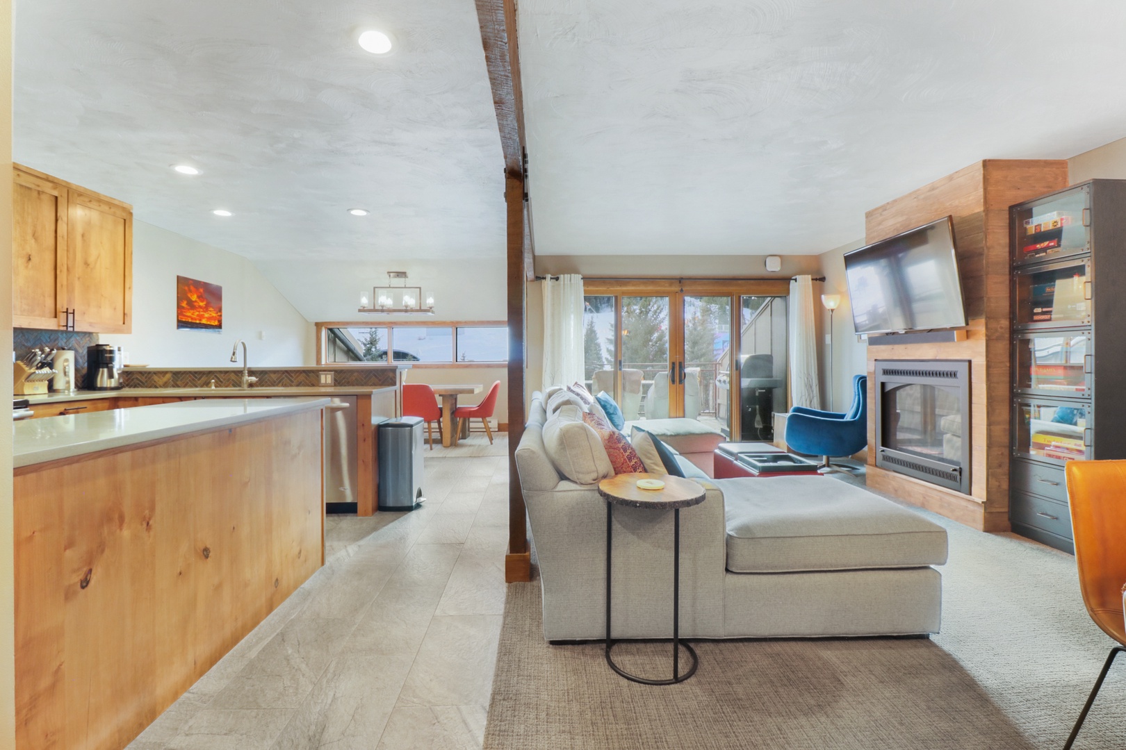 Step into your modern mountain retreat where warm wood tones and contemporary design create the perfect harmony. Relax on plush seating by the cozy fireplace while mountain views frame your stay.