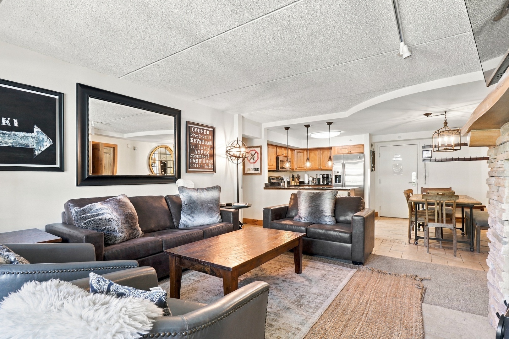 Sink into plush leather seating and rich wood textures in this open-plan living space. The kitchen invites gathering, while cozy throws and soft lighting set the scene for unwinding.