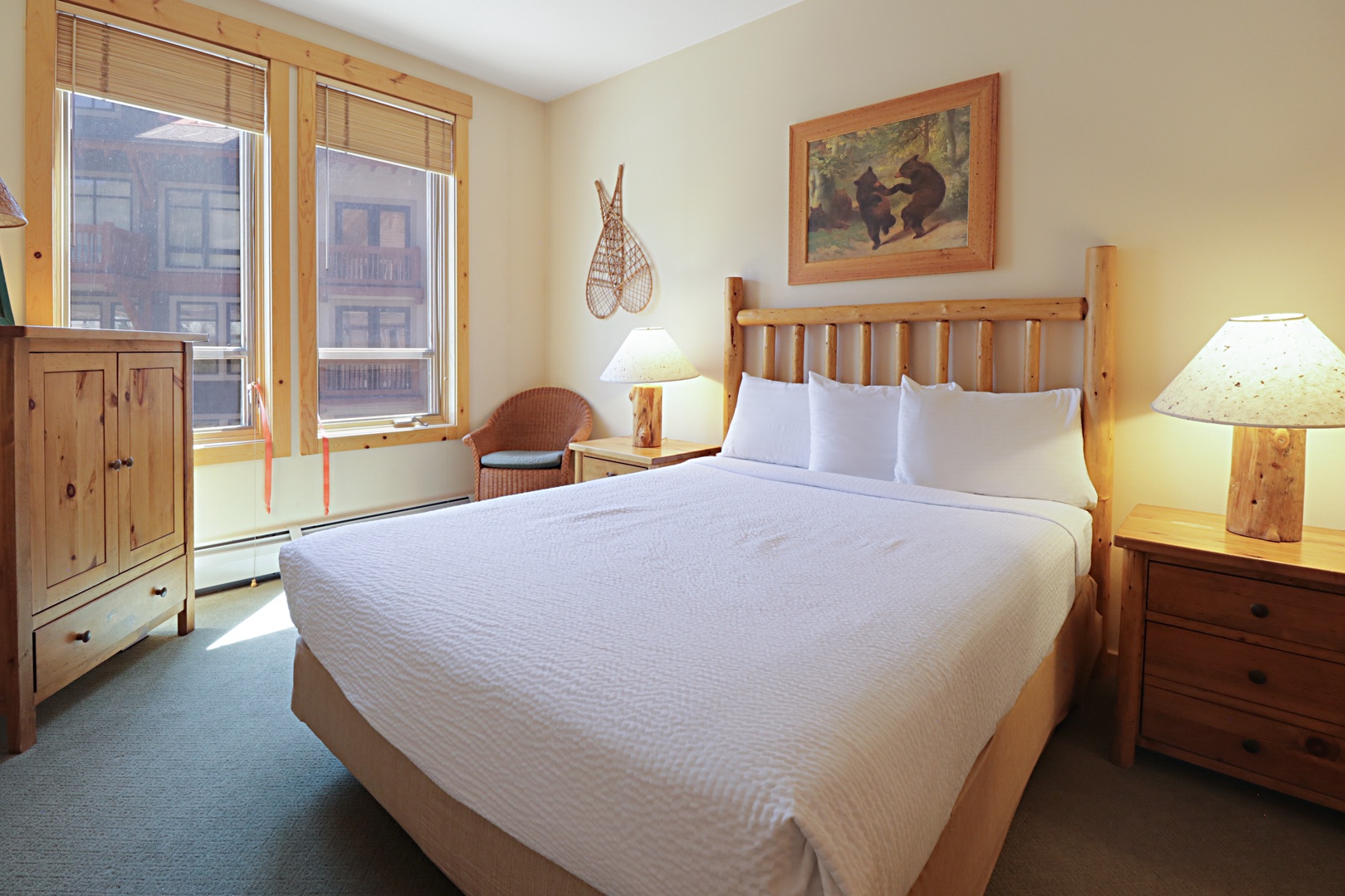 Sink into crisp white linens and rustic charm in your cozy bedroom, where natural wood accents and mountain-inspired decor create the perfect retreat after your adventures.