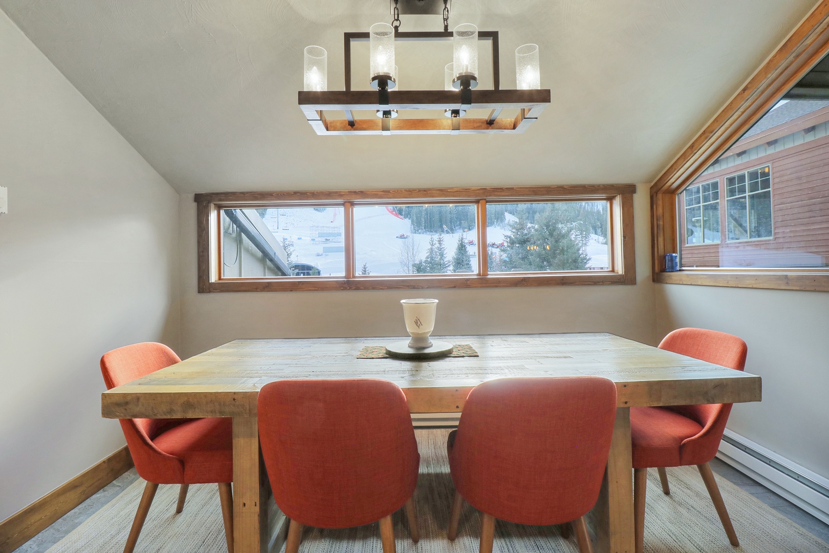 Gather around this stunning rustic dining table where mountain views frame your morning coffee and evening conversations. The warm wood tones and cozy seating create the perfect spot for memorable meals together.