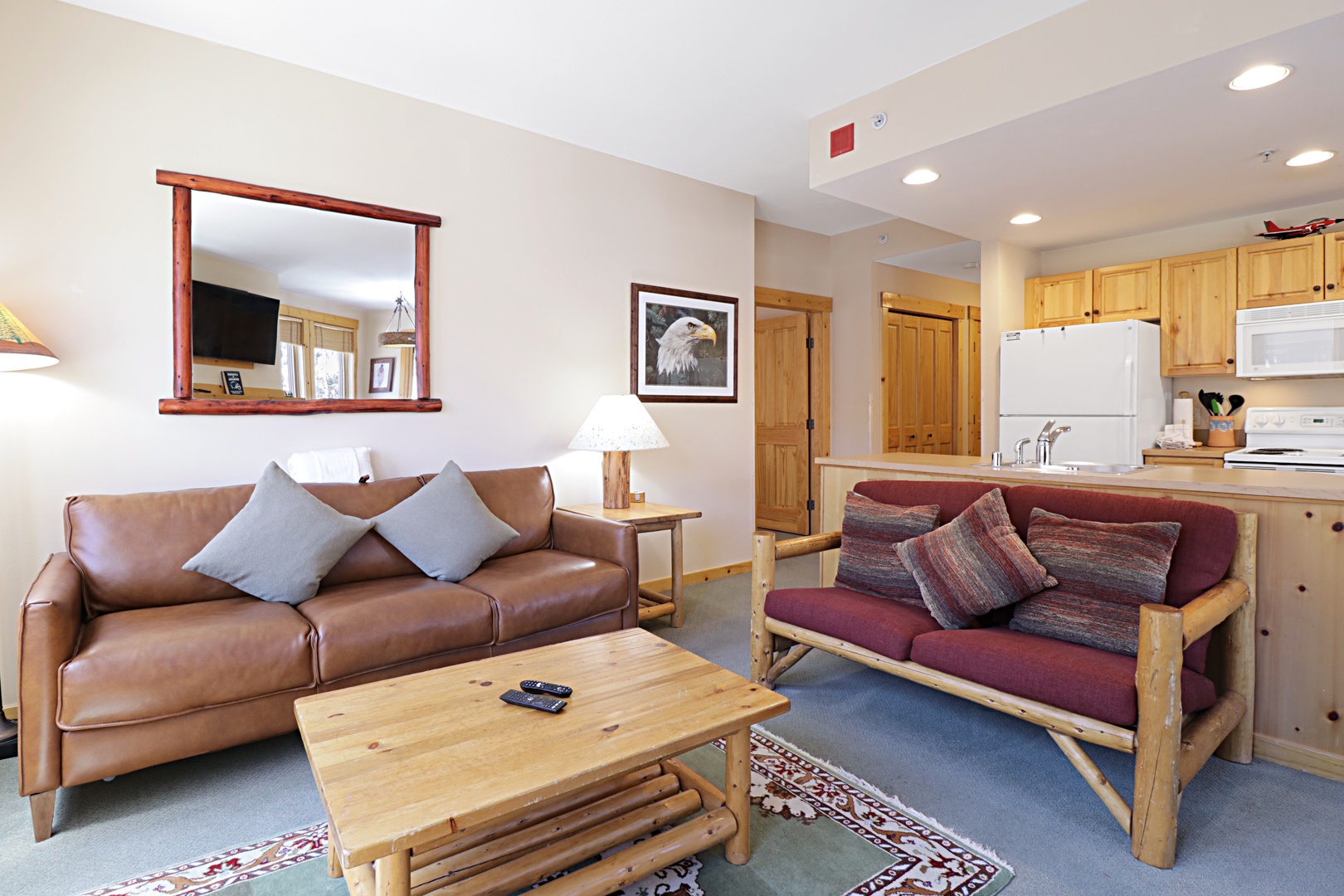 Relax in your cozy living space with leather seating and rustic mountain charm flowing into a fully equipped kitchen.