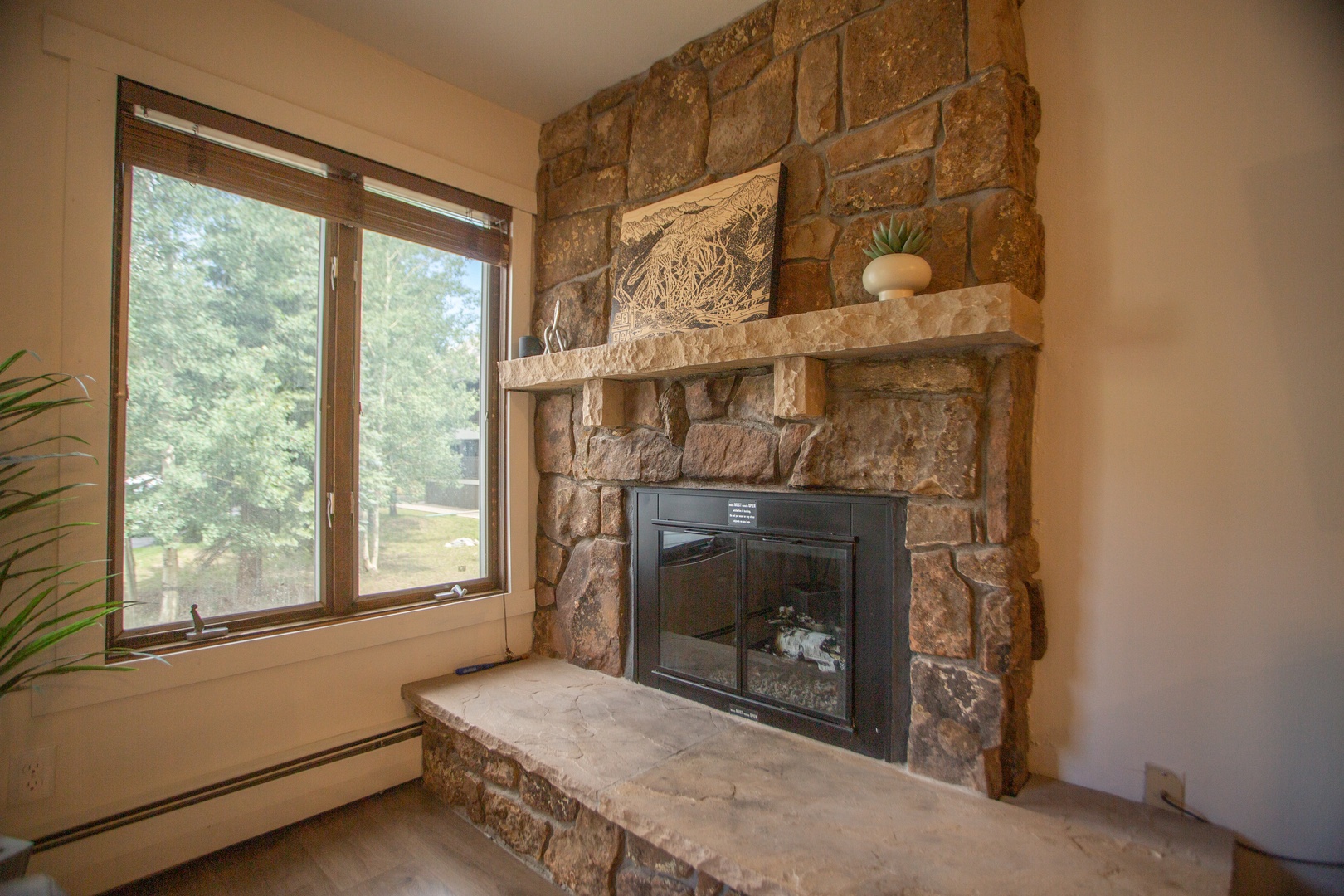 Cozy up beside the handsome stone fireplace with its rustic mantel and enjoy natural light streaming in from your private window—perfect for relaxing after a day of adventure.