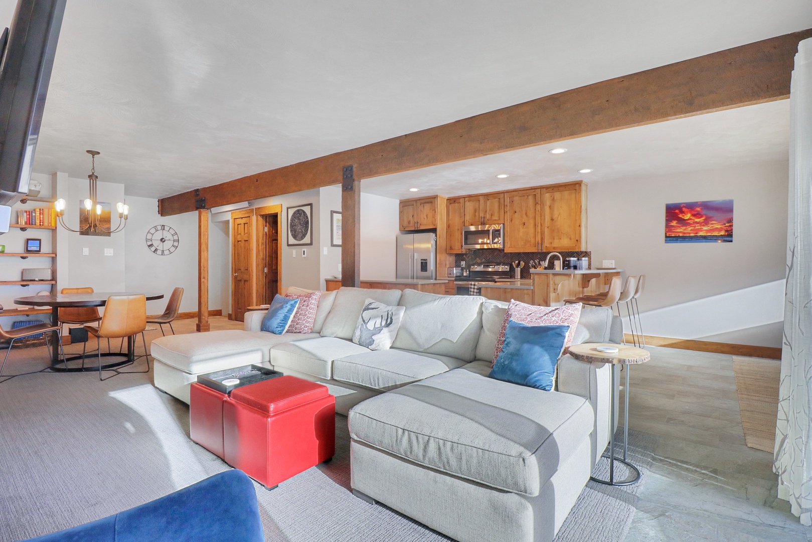 Relax in your spacious open-plan retreat where rustic wood beams meet modern comfort. Sink into the plush sectional sofa while enjoying mountain views, then whip up meals in your fully-equipped kitchen with warm wood cabinets.