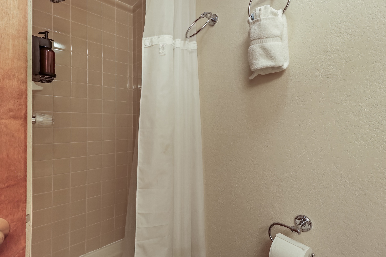 Step into your private bathroom with a refreshing tiled shower, fluffy towels at hand, and thoughtful amenities for your comfort.
