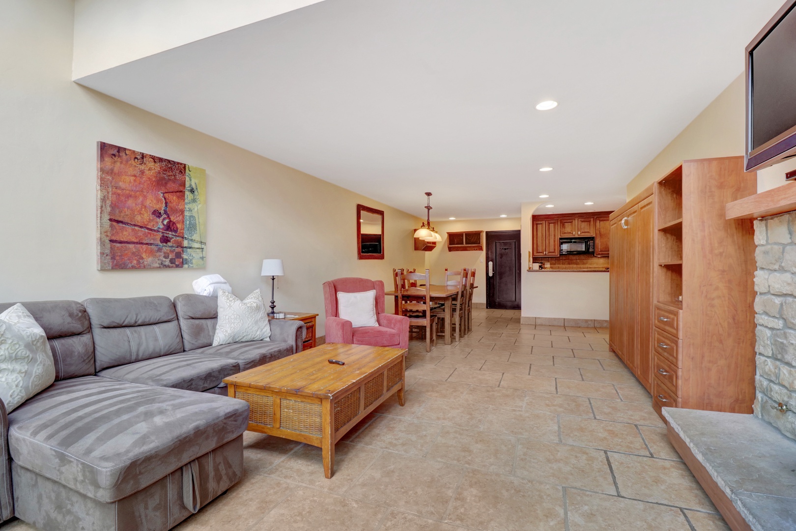 Inviting open floor plan featuring a comfortable sectional sofa, dining table for six, and a fully equipped kitchen. Perfect for entertaining or relaxing after a day on the mountain.