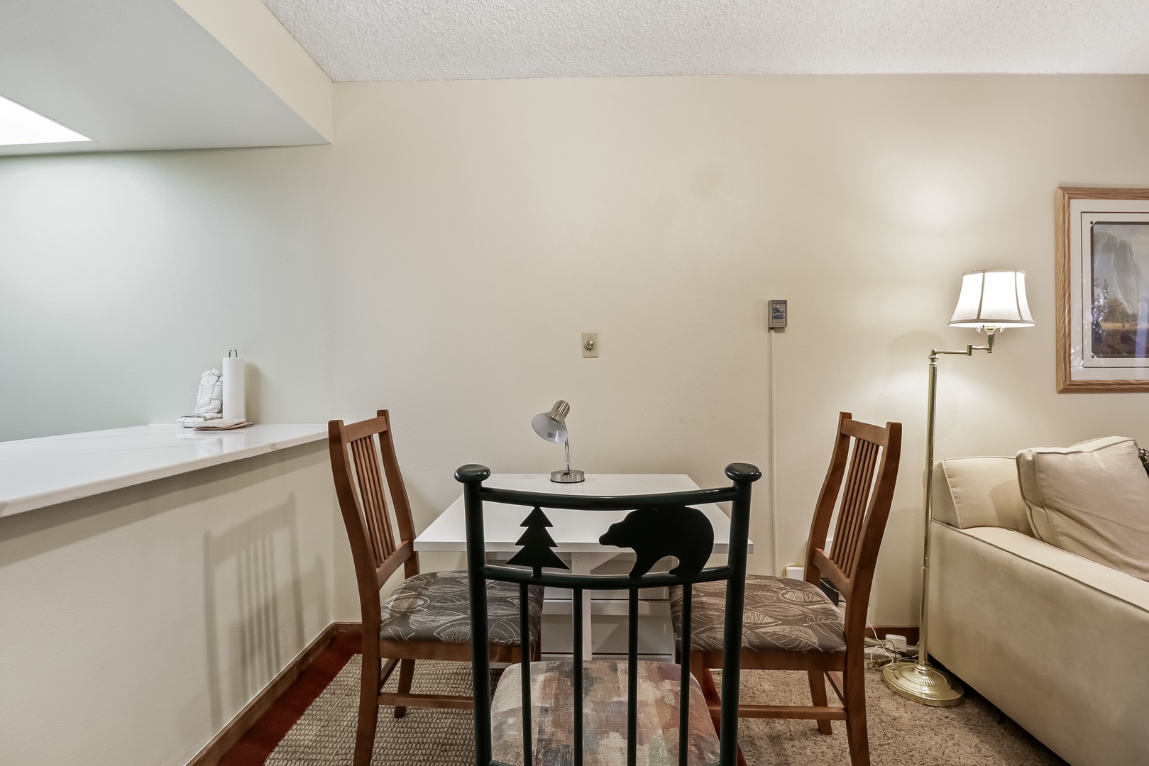 Enjoy intimate meals at your cozy dining table, perfectly positioned near the kitchen counter for easy serving and comfortable conversations.