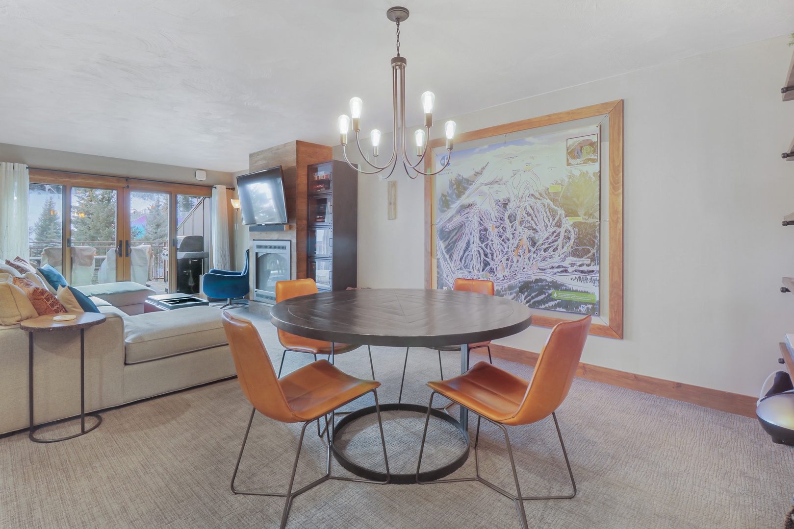 Settle into your stylish mountain retreat where modern comfort meets alpine charm. The open living space invites you to gather around the sleek dining table or sink into the plush sofa while taking in ski slope views through expansive windows.