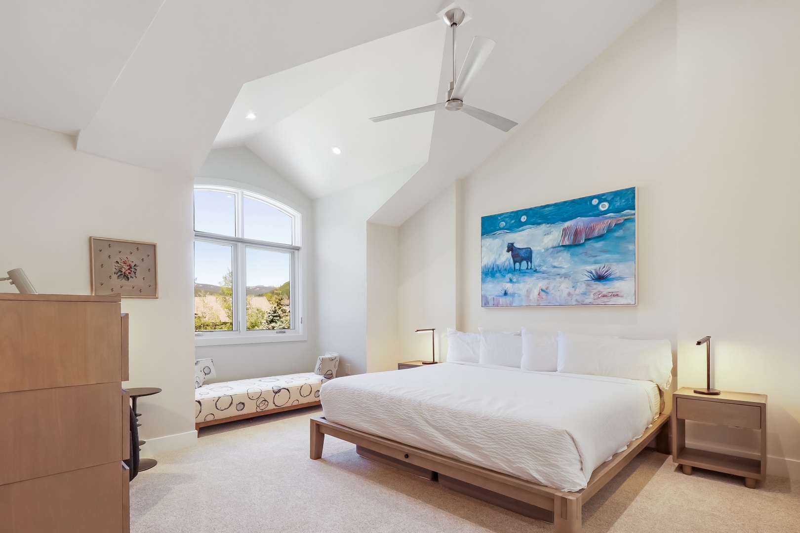 Your bright, spacious bedroom features a vaulted ceiling and sleek ceiling fan to keep you cool. Wake up to natural light streaming through arched windows with scenic views, and unwind in serene comfort.