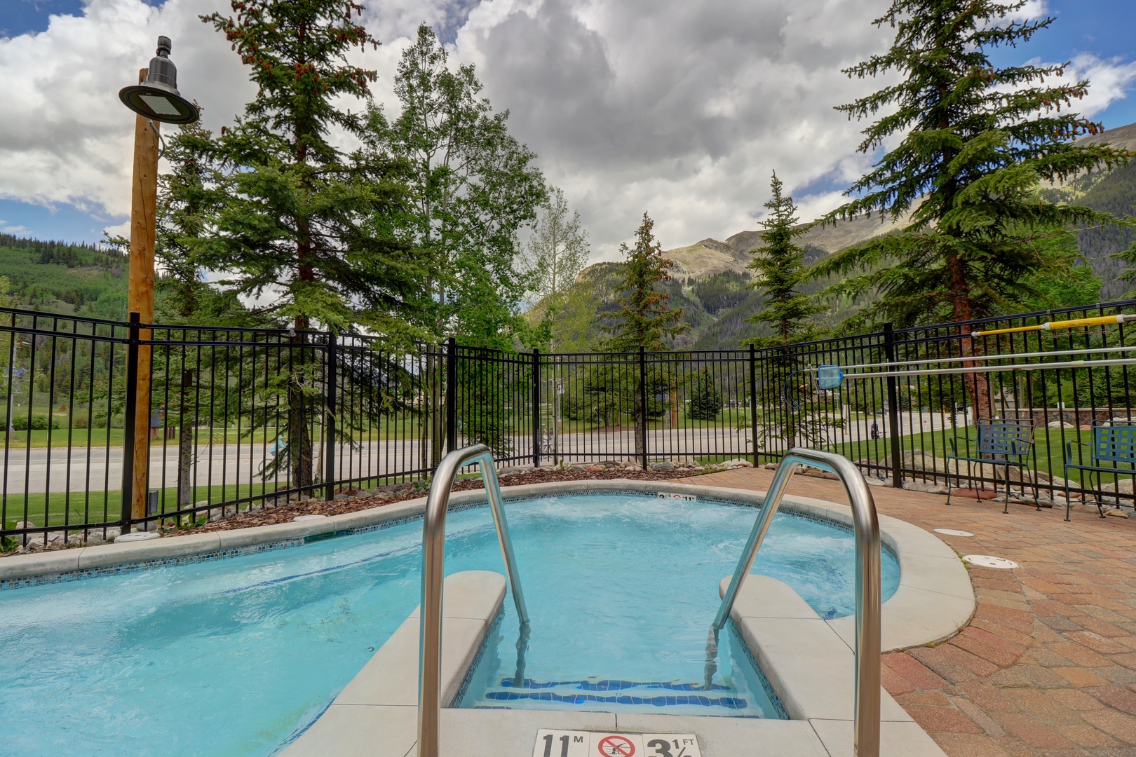 Outdoor hot tub surrounded by stunning mountain views and forest scenery, offering a peaceful alpine retreat with majestic peaks as your backdrop.
