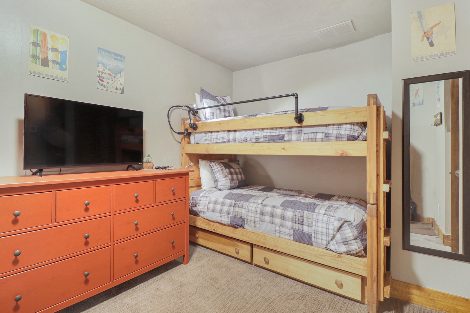 Your kids will love this cozy bunk bed setup! Watch their favorite shows on the flat-screen TV while they settle in for the night. The warm wood bunks and cheerful orange dresser create the perfect space for family memories.