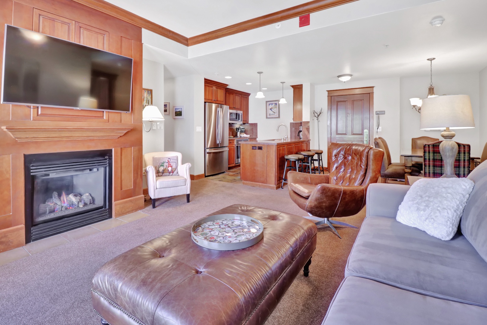 Sink into plush leather seating by the fireplace and feel right at home in this inviting open-concept space, where rich wood tones and modern comfort blend seamlessly.