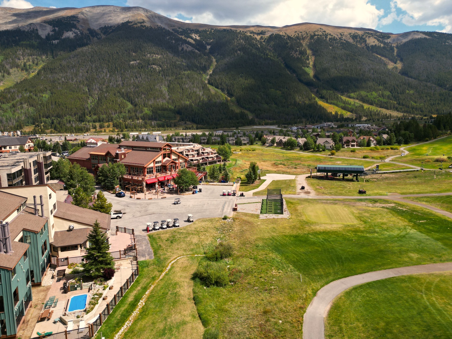 Aerial view of the mountain resort nestled in a pristine valley with ski slopes and golf course nearby.