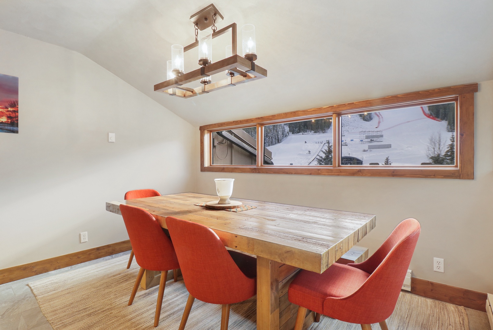 Gather around this rustic dining table where mountain views through panoramic windows create the perfect backdrop for your morning coffee and evening meals together.