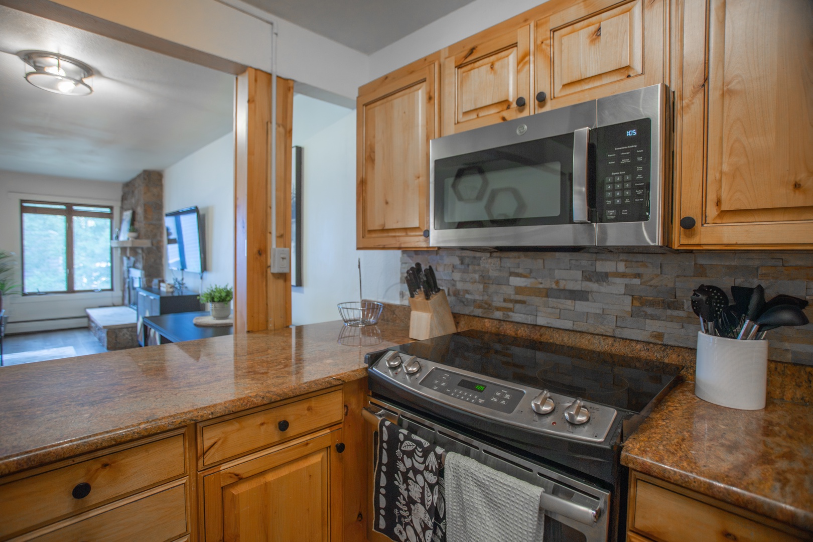 Your fully equipped kitchen features warm wood cabinetry, modern stainless appliances, and granite counters—everything you need to prepare meals in the comfort of your mountain retreat.
