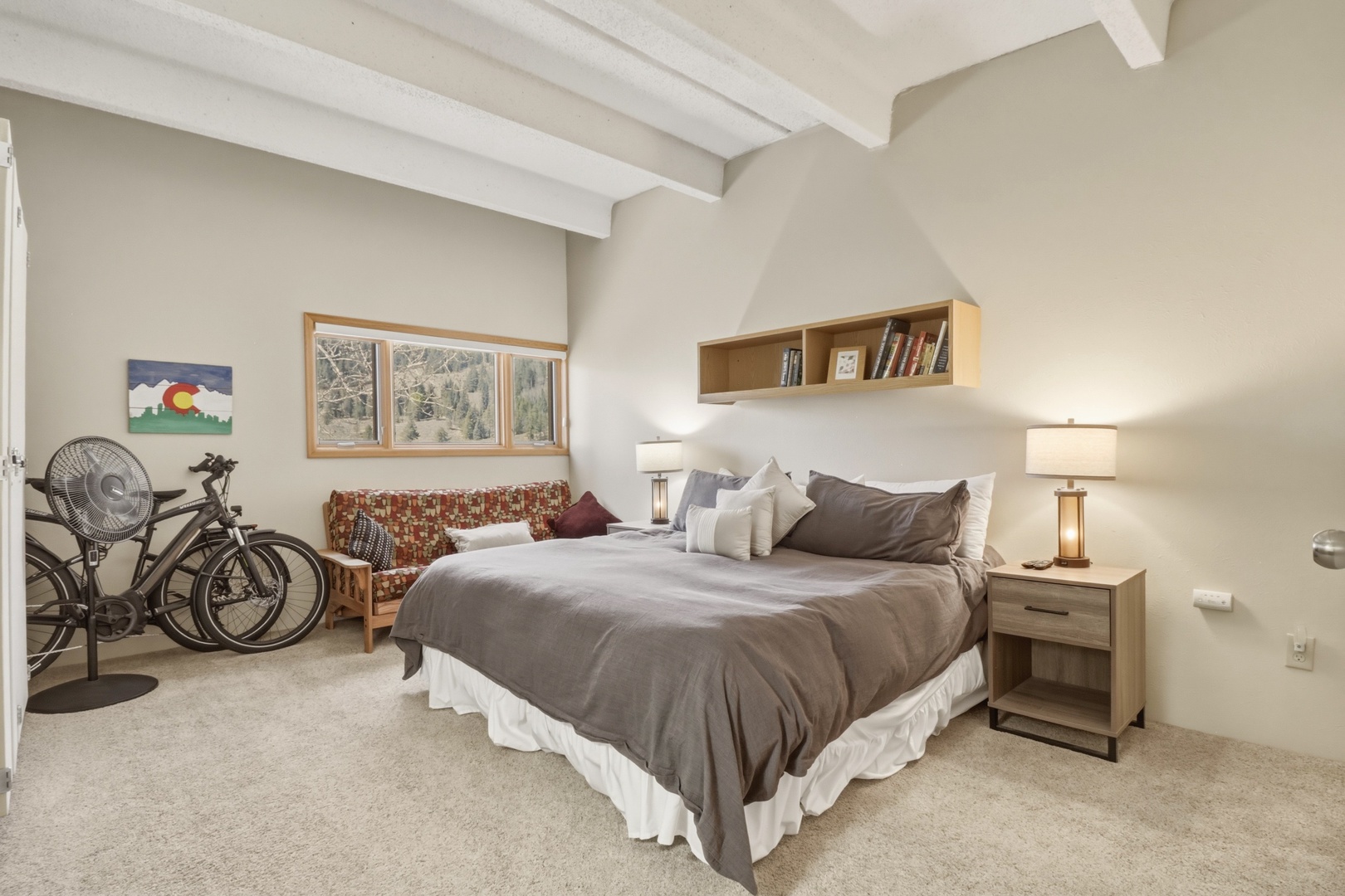 Unwind in your cozy bedroom featuring exposed ceiling beams, comfortable seating, and thoughtful touches like bicycles for exploring.