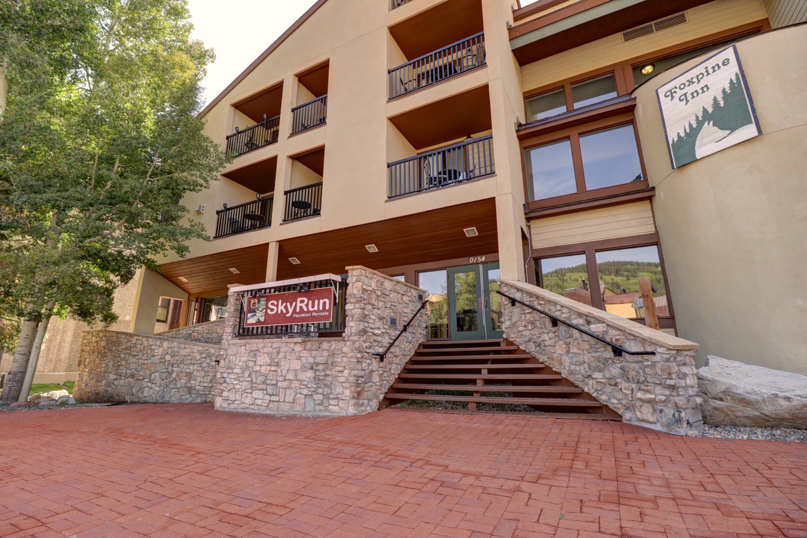 The SkyRun property entrance features stone accents and mountain-themed signage in a peaceful setting.