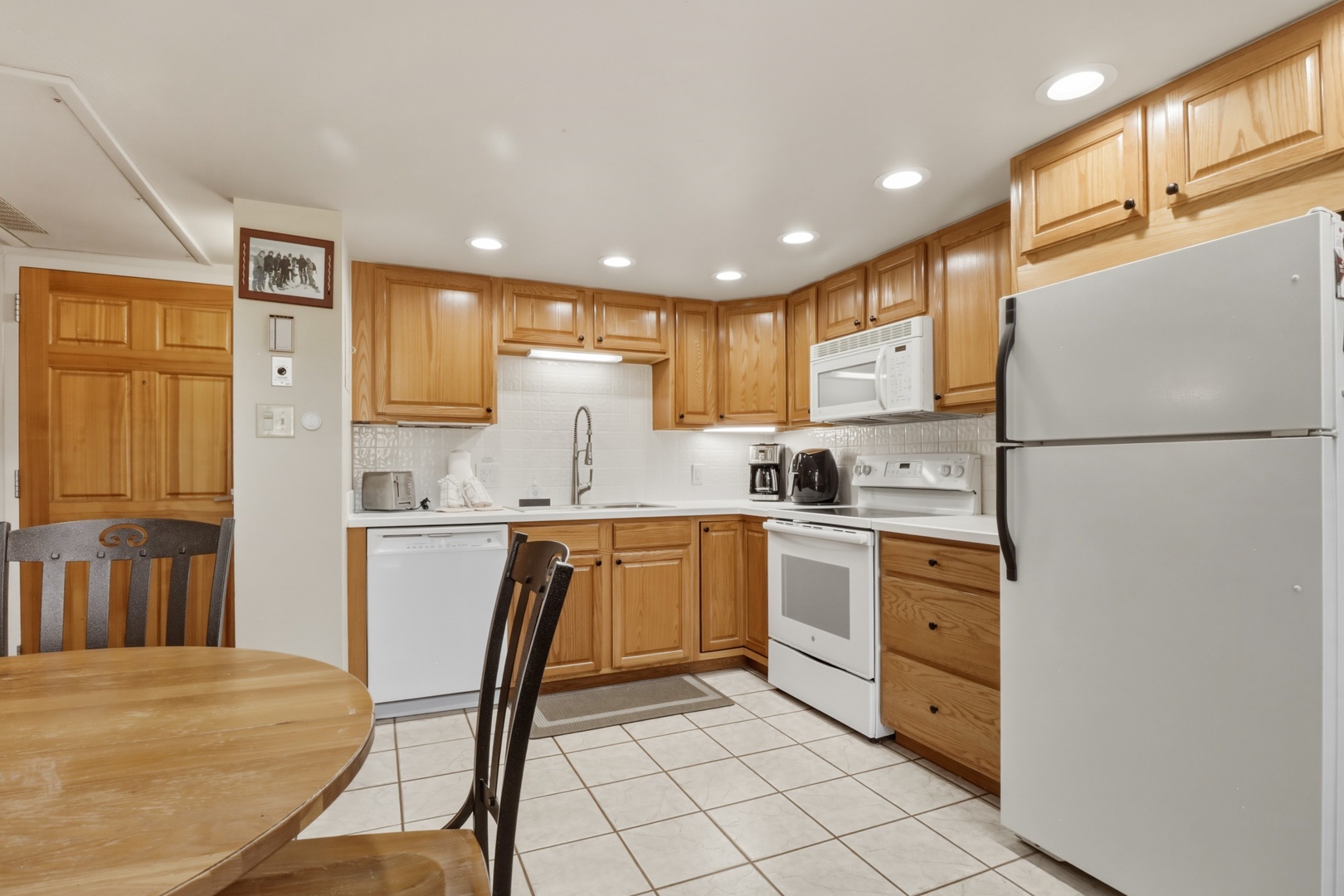 Your fully equipped kitchen features warm wood cabinets, modern appliances, and a cozy dining nook where you can enjoy home-cooked meals together.